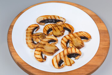 Grilled slices of big button mushroom on a white plate