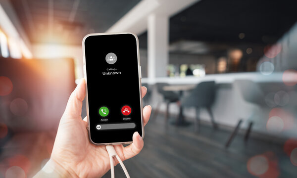 Phone Call Notification from Unknown Number, Sspam, Scammer, Hacker, call Center, Crime internet online,Female hand holding mobile phone with calling sign on screen with blurry coffee shop background - Powered by Adobe