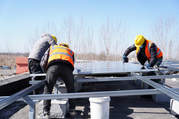 Workers install solar photovoltaic panels