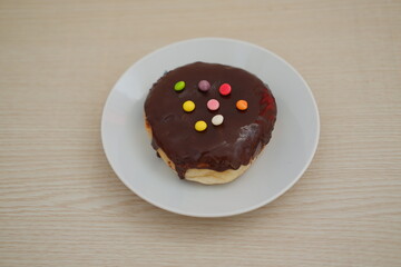Donut with Chocolate Glaze and Colorful Sprinkles on a Plate