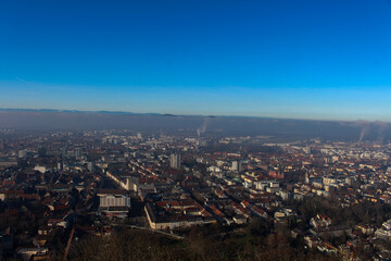 Obraz premium Panoramic view of the foggy city of Freiburg with snow-capped mountain peaks in the background on a winter day