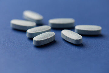 Multivitamin tablets on bright paper background. Close up. Copy space	