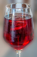 TOP VIEW OF A GLASS OF VERY COLD SUMMER RED WINE WITH ICE CUBES