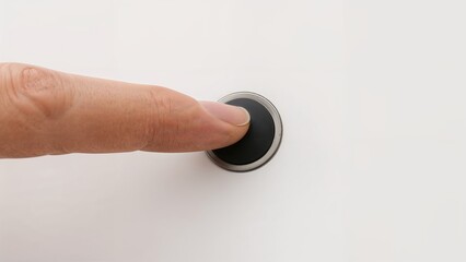 Close-up image of a small dark button being pushed by a finger with a plain backdrop