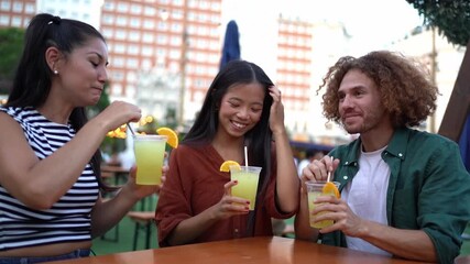 Three friends are sharing a pleasant moment, drinking cocktails at a table in an outdoor bar - Powered by Adobe