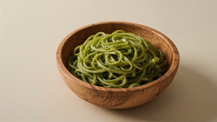 Healthy organic spinach pasta formed into nests served in a wooden dish