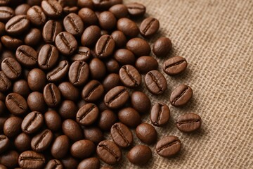 Fototapeta premium Macro view of roasted coffee beans on textile surface
