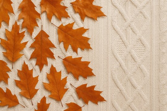 Fall ambiance featuring dried orange leaves resting on a knitted white garment, perfect for seasonal flat lay compositions.
