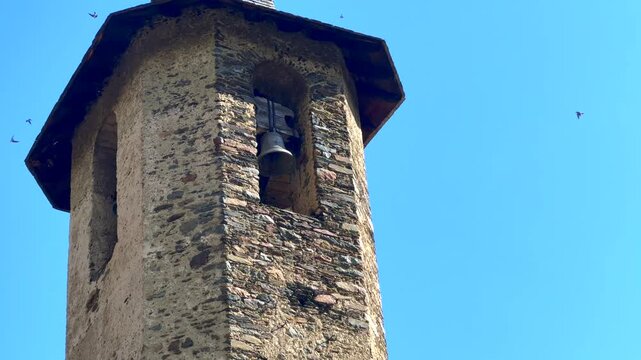 Swallows Around the Old Stone Church Tower &ndash; Pyrenees Village Scene. Areu