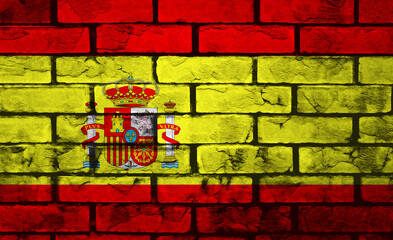 Vibrant Spanish flag painted on rough brick wall adds cultural charm