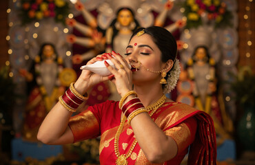 Woman blowing shankh at Durga festival