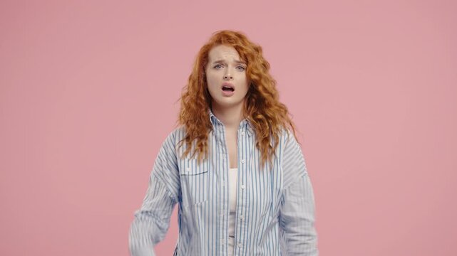Ginger-haired woman rolls eyes, makes blah-blah gesture, bored facial expression