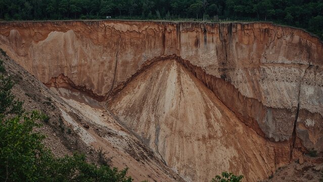 Significant ground rupture and soil displacement on a hillside during heavy rains