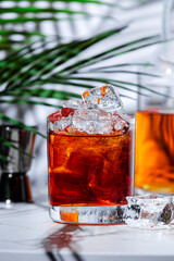 The Bottom Line Strong alcoholic cocktail drink with scotch whiskey, sherry, liqueur, bitters and ice with bar tools