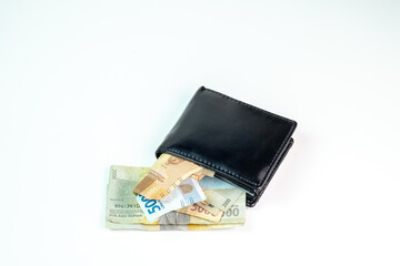 A black wallet containing various Indonesian Rupiah banknotes on a clean, isolated white background. Depicting themes of finance, savings, and transactions.