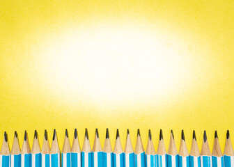 Creative flat lay with row of pencils on yellow background. Perfect for back to school, writing, learning, education and creative design projects. 
