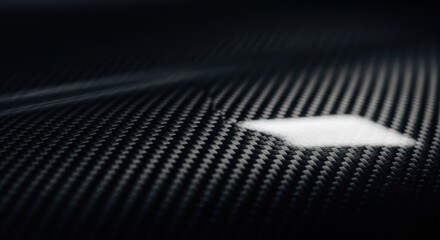 Close-up of dark carbon fiber weave, with a white highlight