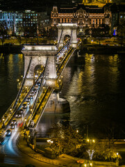 Budapest, Hungary &ndash; Night view of the illuminated Sz&eacute;chenyi Chain Bridge with traffic crossing over the Danube River, showcasing the historic architecture and reflections on the water.
