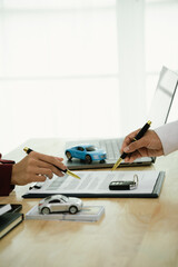 A businessman and client complete an agreement by signing documents for car insurance, loan, or rental, symbolizing finance, contract, policy, investment, purchase, legal paperwork, and secure ownersh