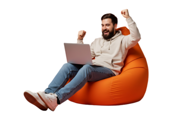 Man celebrating success while using laptop on bean bag isolated on transparent background