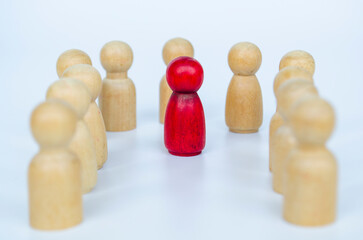 A red figure positioned among other wooden groups, representing inclusion and diversity of it can also be discrimination concept