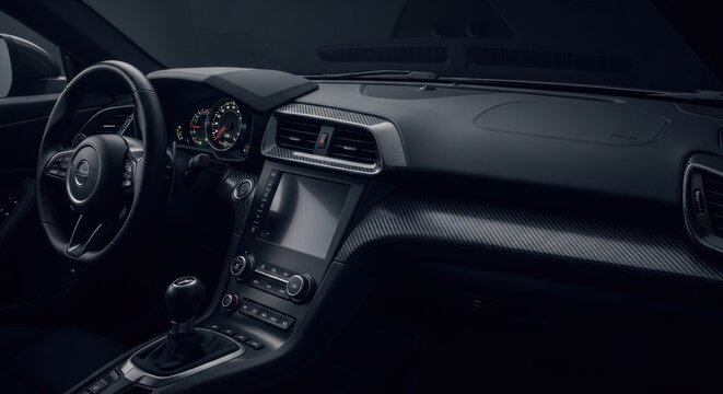 Dark, modern car interior.  Dashboard, steering wheel, and center console highlighted.  Sleek design