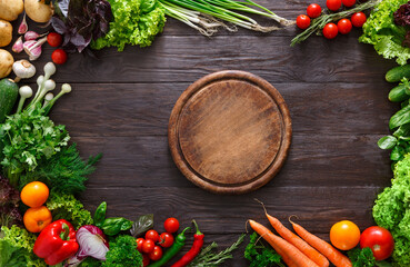 Frame of fresh organic vegetables and wooden desk background. Healthy natural food on rustic wood with copy space. Tomato, lettuce, carrot, pepper, zucchini and other cooking ingredients top view