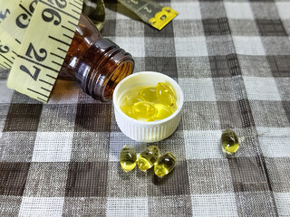 Managing weight and fighting being obese with nutritional supplements and diet control, symbolized by pills and a tape measure.