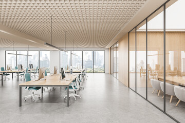 Modern open space office interior with workstations, glass meeting room and city view through large...