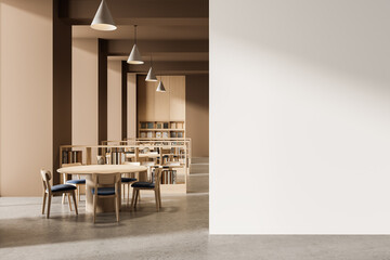Modern library interior with round table and chairs next to blank white wall for design mockup in warm minimal setting with pendant lights and bookshelves. 3D Rendering
