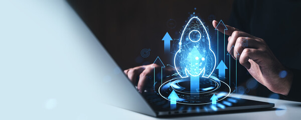 Startup launch and growth concept with glowing rocket icon and arrows above laptop, symbolizing innovation and business development progress.