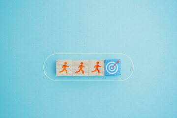 Illustration of goal progression represented through three wooden blocks featuring running figures and a target symbol.