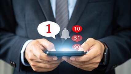 Man in suit holding smartphone with social media notification bubbles and bell icon