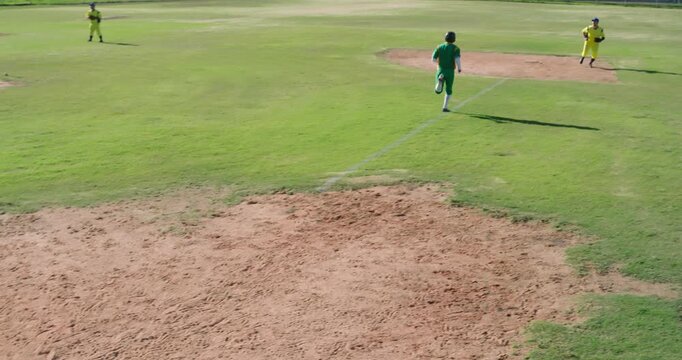 Pitch ending sparking male players sprinting to score, chasing, resetting around third base