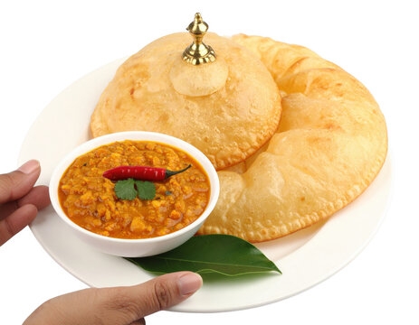 Festive Indian Dal Kachori a golden puffed bread with a decorative finial served with lentil curry.