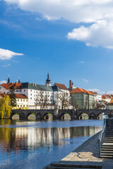 Stone Bridge reflecting on Otava River in Pisek, Czechia