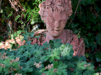 deteriorated statue of a man in the woods
