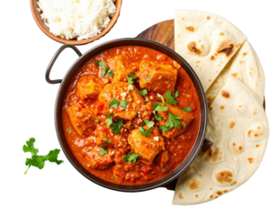 Traditional Indian chicken curry in a karahi bowl with naan bread and rice garnished with fresh cilantro.