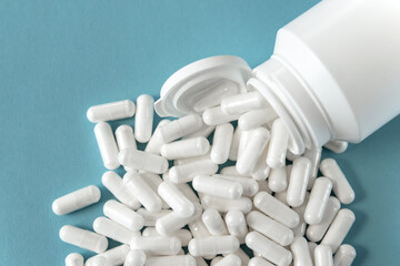 White tabletts or pills on the blue background.