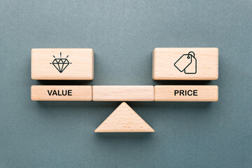 Wooden blocks on balance scale showing value and price icons, concept of cost, worth, business decision, financial strategy, customer perception