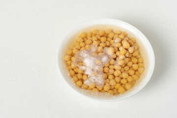 Boiled chickpeas. In a white bowl. On a white background. Ready to prepare any delicious recipe.