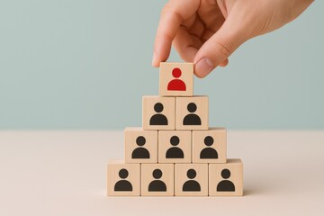 Leadership Hierarchy Concept: Hand Placing Leader Block Atop Wooden Pyramid Representing Team Structure and Management