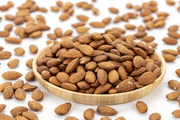 Roasted almonds wooden plate healthy snack protein nut food isolated white background