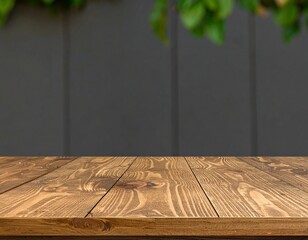 Wooden tabletop against a blurred gray wall with greenery
