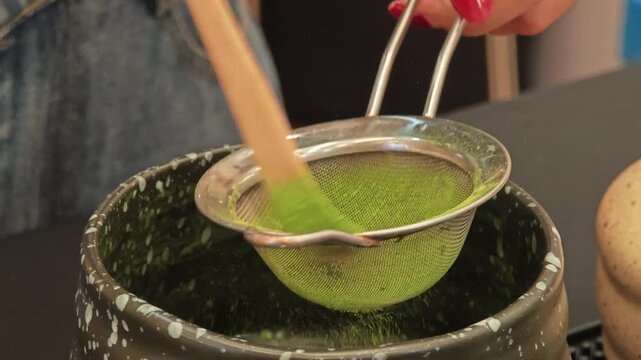 Matcha green tea powder on a net strainer