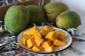 Rajapuri mangoes with diced ripe pieces show green skin and orange flesh, showing ripening stages
