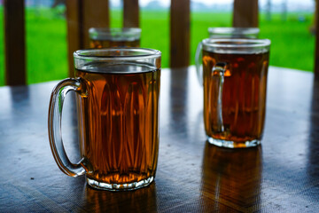 A row of hot tea glasses on a table with a natural background, the concept of the beverage and food menu.