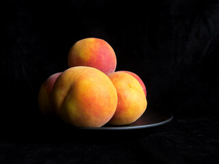 Peaches on black background. Fresh ripe organic fruits, whole and sliced peach, healthy food concept