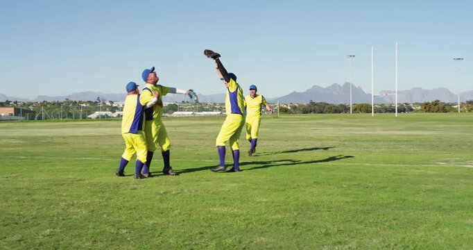 Diving fielder securing final out with ground ball prompting male teammates cheering on field