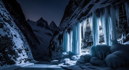 Frozen gorge with illuminated icicles and snowy peaks under a night sky